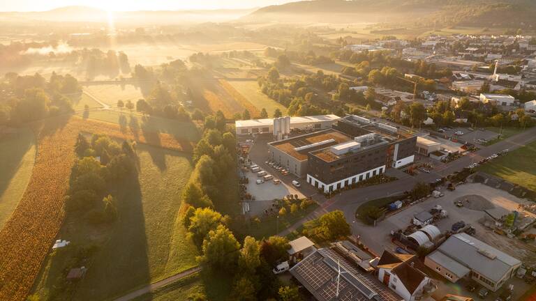 Eine Luftaufnahme zeigt das den Hauptsitz der Stadtwerke Schorndorf mit Sonnenaufgang.